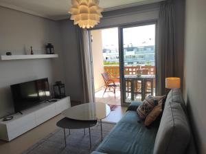 a living room with a couch and a tv and a table at Tejita Playa in Granadilla de Abona