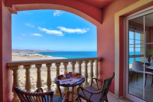 a balcony with a table and chairs and a view of the ocean at Mar de Horizonte in Costa Calma