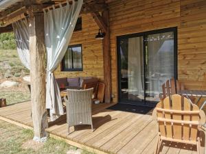 um camarote com um deque com cadeiras e um pátio em La Peyregoune, logement en pleine nature et table d'hôtes em Blieux