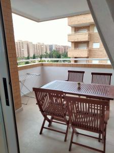einen Balkon mit einem Holztisch und 2 Stühlen in der Unterkunft Confort y Relax in Oropesa del Mar