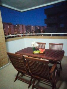 einen Holztisch mit Blumen auf dem Balkon in der Unterkunft Confort y Relax in Oropesa del Mar