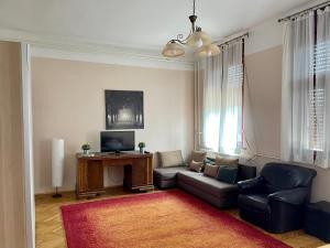a living room with a couch and a tv at Rudolf House in Budapest