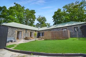 a stone house with a garden in front of it at 5 Bed Barn Conversion - with private hot tub in Birchington
