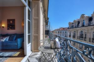 a balcony with a table and a couch at Maison Lamartine - Nice in Nice