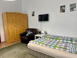 una camera con letto, sedia e TV di Rudolf House a Budapest