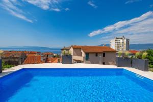 a large blue swimming pool on top of a house at Apartments Vila Belvedere in Rijeka