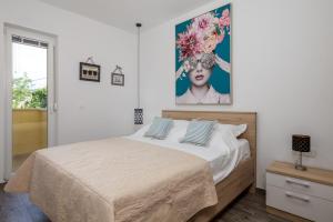a bedroom with a bed with a painting on the wall at Apartments Vila Belvedere in Rijeka +73 photos