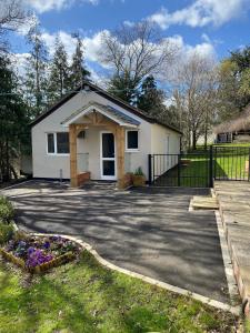 a small white house with a driveway at Chase Bungalow in Billericay