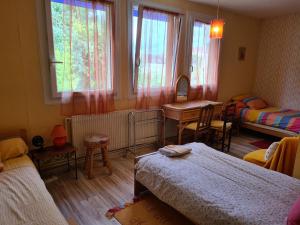 a bedroom with two beds and a table and a desk at Maison Saint Louis in Paray-le-Monial