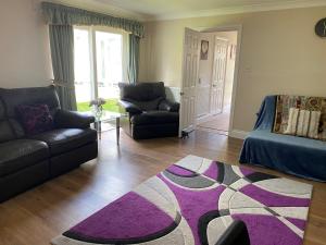 uma sala de estar com dois sofás e um tapete roxo em Chase Bungalow em Billericay