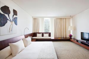 een hotelkamer met een bed en een televisie bij COMO Metropolitan Bangkok in Bangkok