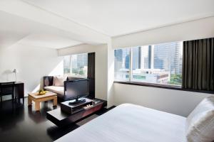 a hotel room with a bed and a television at COMO Metropolitan Bangkok in Bangkok