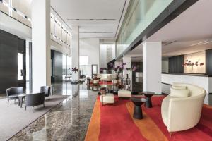 a lobby with couches and chairs and a red rug at COMO Metropolitan Bangkok in Bangkok