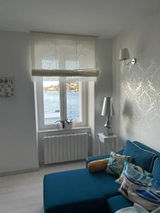 a living room with a blue couch and a window at Apartman Priko 63A in Mali Lošinj