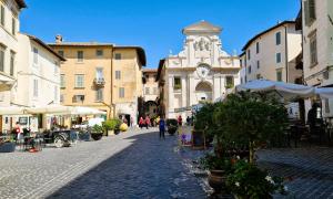 eine Straße in einer Altstadt mit einem Uhrturm in der Unterkunft Appartamento San Martino in Spoleto