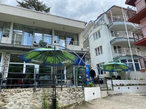 two umbrellas sitting in front of a building at Pensiunea Ambasador in Băile Herculane