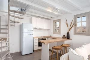 Una cocina con un refrigerador blanco y una encimera. en Aura Homes, Bungalow on Sea - Saint Anna Beach, en Mykonos ciudad