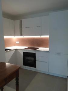 a kitchen with white cabinets and a stove top oven at Dimora Deva in Pescara