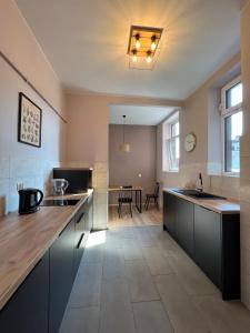 a kitchen with blue cabinets and a dining room at Apartamenty Rynek 7 in Cieszyn