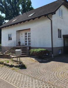 a white house with a brick driveway in front of it at Ferienwohnung in der Siedlung in Klinga
