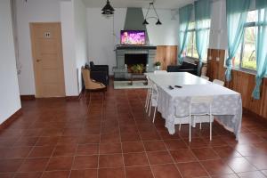 a living room with a table and chairs and a tv at Albergue La Corona1 in O Pino 