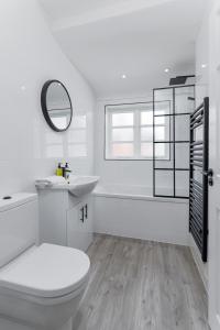 a white bathroom with a toilet and a sink at Air Host and Stay - Beautiful modern Rodney Street apartment in Liverpool