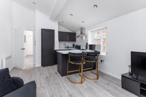 a kitchen with black cabinets and a counter with stools at Air Host and Stay - Beautiful modern Rodney Street apartment in Liverpool