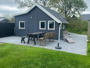 a picnic table and bench in front of a house at Blokhut Klein Meerzicht in Haren