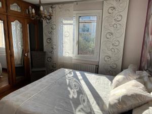Schlafzimmer mit einem Bett und einem Fenster in der Unterkunft Haut de villa très bien équipé avec jardin, piscine, proche centre ville Sanary in Sanary-sur-Mer