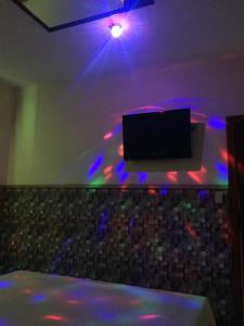 Impérium Inn Motel (Adult Only) في Nova Ponte: تلفزيون على جدار في غرفة مع أضواء