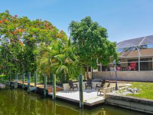 a house with a dock in a body of water at Waterfront Pool Villa with Sailboat access in Cape Coral