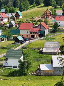 un petit village avec des maisons sur une colline dans l'établissement Deluxe Studio & Rooms Zarubica, à Žabljak