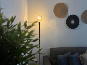 a floor lamp in a living room next to a couch at Luxury Lavender in Larnaca