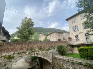 un vecchio ponte di pietra sopra un fiume in una città di Hotel San Francesco e il lupo a Gubbio