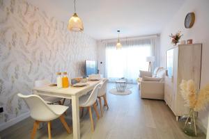 Una sala de estar con mesa de comedor y sillas. en GALIHOST - Impresionante apartamento con piscina en Sanxenxo, en Sanxenxo