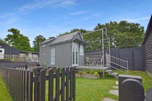 a tiny house in a yard with a fence at The Shepherd's Hut, Quex Park Estate in Birchington