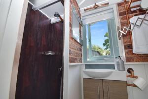 a bathroom with a sink and a window at The Shepherd's Hut, Quex Park Estate in Birchington