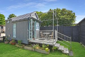 a tiny house with a deck and a table at The Shepherd's Hut, Quex Park Estate in Birchington +13 photos