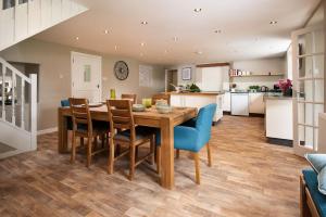 a kitchen and dining room with a wooden table and chairs at Pirnie Cottage in Kelso