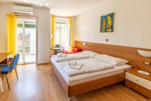 a bedroom with a bed and a table and a desk at Apartments Liburnija in Opatija