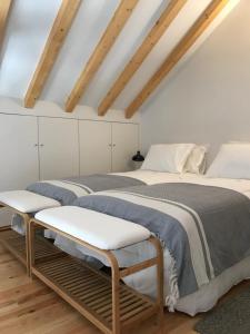 Cette chambre comprend 2 lits dans une chambre dotée de murs blancs et de plafonds en bois. dans l'établissement Casa Girasol River View, à Porto