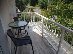 un balcón con 2 sillas y una mesa en un porche en Sommer Ferienhaus, en Balatonszárszó