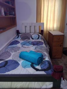 Un dormitorio con una cama con objetos azules. en Habitación en casa con pileta en Río Ceballos en Río Ceballos