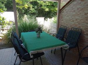 una mesa verde y sillas en un patio en Sommer Ferienhaus en Balatonszárszó