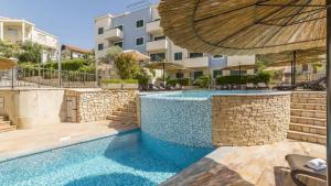 a swimming pool in front of a building at Apartment Clementin in Slatine