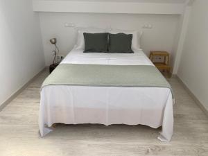 a bedroom with a large white bed with green pillows at Villa Sesimbra in Sesimbra