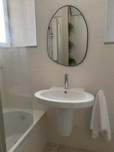 a white bathroom with a sink and a mirror at Villa Sesimbra in Sesimbra +19 photos