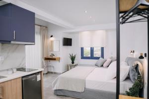利迈纳里亚BLUE STONE Luxury Suites的一间带大床的卧室和一间厨房