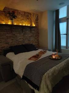 a bedroom with a large bed and a brick wall at Au Spa de LLEA in Avignon
