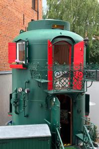 a green and red train sitting next to a building at City-Kesselhaus-Stendal in Stendal